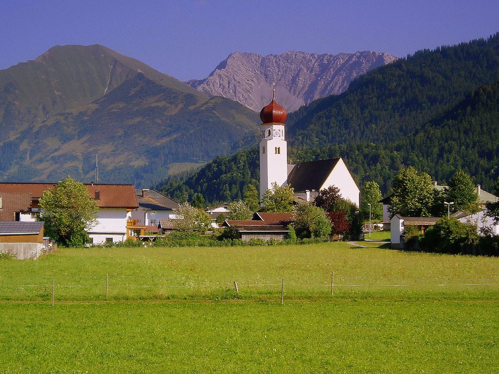 Österreichische Landschaft mit Dorf, Bergen und klarer ruhiger Weite.